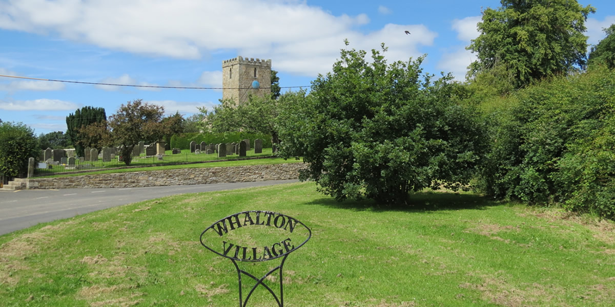 Whalton_Village_sign_with_St_Mary_Magdalenes_Church_in_background.jpg